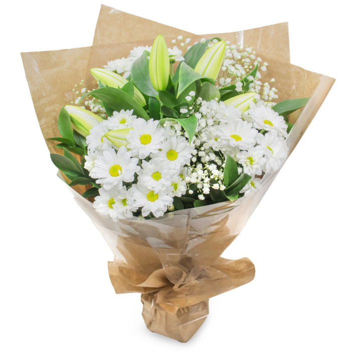 An elegantly composed bouquet presented upright against a white studio background, this arrangement celebrates the serene palette of white and green with considered craftsmanship familiar to Flowers Oxford. The central mass is made up of numerous white, daisy like chrysanthemums whose concentric layers of petals open to soft yellow centres, creating a cheerful yet gentle anchor. Scattered through the cluster are elongated lily buds in a pale green-yellow tone, some with subtle striping; their unopened forms introduce a sense of unfolding narrative and refined anticipation. Wisps of baby s breath (Gypsophila) are woven between the larger flowers, their tiny, cloud-like blossoms adding a delicate, ethereal texture that softens and harmonises the grouping. Rich dark green foliage gives the bouquet structure and contrast, the glossy leaves tucking beneath blooms to add depth and a verdant frame. The stems are hand-tied by an experienced hand and wrapped first in crinkled brown kraft paper to give an organic, tactile base, then protected with an outer layer of clear cellophane that catches the light and preserves the bouquet s freshness; the wrapping is neatly gathered and secured at the base to form a comfortable, stable stand. In soft daylight the arrangement feels calm and pure, its fragrance subtle and clean with a faint green, grassy undertone. Suitable for a wide range of occasions from quiet remembrance to joyful congratulations, it evokes the quiet charm of an Oxford morning near the Covered Market or along St Giles, and can be ordered through Flowers Oxford at flowersoxford.info for local delivery or collection.