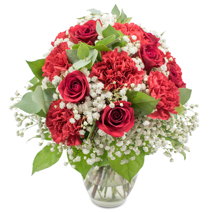 A striking red and white bouquet is arranged with great care in a simple clear glass vase, photographed against a flawless white backdrop that makes the colours appear especially vivid. Dominating the composition are deep crimson red roses, their petals densely layered in graceful spirals, each bloom offering that classic symbol of romance and enduring affection. Nestled among them are numerous red carnations, their softly ruffled petals creating a plush, almost cushion-like texture that adds body and movement to the design. Drifting through the arrangement is a generous scattering of pure white baby's breath, each tiny flower forming part of a delicate, cloud-like mist that gently lightens the bold reds and introduces a feeling of purity and calm. Sprigs of greenery, from the darker, slightly glossy rose leaves to rounded eucalyptus in soft, silvery-green, emerge between the blossoms, breaking up the colour blocks and lending subtle structure and depth. The stems can be clearly seen through the transparent vase, standing in clear water and testifying to professional preparation and freshness. The overall shape is full and rounded, with no harsh edges, just a harmonious dome of colour and texture. Under the bright, even lighting, the bouquet feels appropriate for many Oxford settings: a romantic dinner table in North Oxford, a celebratory gift near Magdalen Bridge, or a thoughtful gesture for someone working around the city centre colleges. With its balanced mix of passion, elegance, and tenderness, this arrangement suits anniversaries, Valentine's Day, graduations, or any heartfelt occasion where red roses and carnations can speak for you.