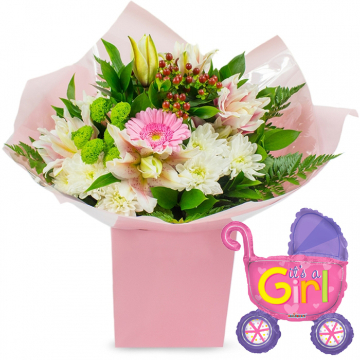 This image shows a beautifully coordinated baby girl celebration display, thoughtfully styled in a soft palette of pinks, whites, greens, and a few joyful splashes of purple and yellow. At the centre, resting on a white surface, is a tall, square, light pink gift box that has been carefully filled with a hand-crafted floral arrangement. The bouquet appears freshly arranged by an experienced Oxford florist, with each stem positioned to create both height and fullness. Dominating the middle is a bright, soft pink gerbera daisy, its petals forming a perfect circle that naturally draws the eye. Surrounding it, clusters of pristine white chrysanthemums, with their multi-layered petals, form a gentle cushion of texture. Interspersed within are alstroemeria lilies in light pink and white, lightly speckled and edged with subtle striping, which lend the display a touch of refinement. Slightly above the main cluster, a closed yellow lily bud leans forward, suggesting new petals waiting to unfurl, echoing the sense of a new life just beginning. The bouquet is enriched with vivid lime-green button-style blooms, sprigs of deep red hypericum berries, and generous greenery, including glossy leaves and feathery fern fronds that spill naturally over the top of the box. The flowers are wrapped in layers of soft pink tissue paper and clear cellophane, their folds catching gentle reflections in the studio light. To the right of the flowers, a playful foil balloon shaped like a classic baby stroller floats at the same height. The stroller balloon is predominantly hot pink, with a deeper purple hood and two round purple wheels decorated with colourful spokes. Across its side, the words It's a Girl! are printed in bold yellow and green lettering, surrounded by tiny heart accents. Together, the bouquet and balloon create a joyful, ready-to-give gift, perfect for sending congratulations to an Oxford maternity ward or welcoming a new daughter home to a townhouse off Banbury Road or a cosy flat near the River Thames.