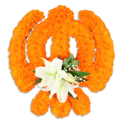This floral emblem breathes with colour and quiet intention: thousands of small, bright orange marigold blooms have been coaxed into a precise shape that expresses the Khanda's sacred geometry - the circular chakkar, the pair of crossed swords and the central upright blade - their dense, cushiony heads creating a warm, tactile field that seems to glow. Nestled at the intersection is a cluster of serene white lilies - two or more fully open, their petals unfurling with soft curves and revealing pale yellow-green stamens - surrounded by smaller buds that promise more bloom. Lush green leaves arc around the central lilies and delicate clusters of baby's breath (gypsophila) float like gentle breathing clouds against the orange, softening the composition and adding depth. The studio lighting sculpts the petals, bringing out the marigolds' layered texture and the lilies' satiny sheen, while a fine drop shadow beneath hints that the piece is a freestanding display. As a florist who works with Oxford's communities - from market mornings in the Covered Market to festival gatherings near the University Parks - I imagine this arrangement placed on a respectful dais during Vaisakhi or a commemorative service, its scent filling the air with warm spice and cool floral clarity. It reads as both a bold celebration and a tender offering, designed to be felt as much as seen by friends and neighbours across Summertown, St Giles and beyond.