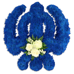 A striking Sikh Khanda funeral tribute dominates a clean white backdrop, its iconic silhouette fashioned from a dense carpet of royal blue chrysanthemums or similar small-headed blooms. Every curve of the chakkar ring, every line of the central khanda sword, and each arc of the two flanking kirpans is crisply defined in the same intense blue, giving the tribute a sense of unity and spiritual strength. The flowers are packed closely together so that, from a distance, the surface appears almost like soft velvet, yet up close each tiny floret adds its own texture and life. At the lower part of the central circle, a graceful accent of white and green draws the eye. Three serene white roses sit at the centre, their petals gently unfurling, surrounded by airy clouds of delicate white filler flowers that might be gypsophila. Small, polished green leaves cradle this cluster, providing a natural frame and a refreshing contrast to the sea of blue. The lighting is even and gentle, allowing the colours to stand out clearly, much like a carefully laid tribute in a quiet chapel in Oxford, perhaps for a service near Summertown or along Iffley Road. This floral Khanda feels both solemn and comforting, reflecting a deep understanding of Sikh customs and the importance of honouring a loved one's heritage. It would be a meaningful choice for families seeking a respectful, culturally significant piece that expresses devotion, remembrance, and enduring faith at a funeral or memorial ceremony.