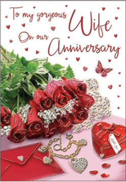 This anniversary card design unfolds like a private love letter arranged on a table near Oxford's High Street, where soft daylight pours across every detail. A posy of crimson red roses dominates the scene, each bloom full and velvety, with petals unfurling in swirling layers that look almost touchable. Glossy green foliage is tucked closely around the flowers, giving depth and movement, as though the bouquet has just been placed down after a walk through University Parks. The background is romantic and slightly shimmering, scattered with tiny heart accents that seem to float around the central message. Resting beside the roses is a plush scarlet jewellery box tied with a neat ribbon, its fabric surface richly textured, along with a golden necklace shaped like intertwined hearts that glints softly. Sparkling decorative elements dot the card like stardust, enhancing the mood of celebration. The scripted anniversary text curves gracefully across the design, its elegant lettering drawing the eye through the composition. The light is gentle but glowing, adding a halo-like warmth to the reds and blush hues, suggesting candlelit dinners and cherished memories. Crafted with the sensitivity of an experienced florist, this still life captures enduring devotion and the promise of many more anniversaries to come, ideal for couples across Oxford who want their love to feel beautifully acknowledged and tenderly honoured.