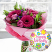 A vibrant birthday gift set is displayed in soft natural light, featuring a lush pink bouquet and a shiny Happy Birthday balloon, as if waiting on a kitchen table in an Oxford townhouse near the Covered Market. The flowers are gathered in a clear glass cylinder vase, stems visible through the water, and surrounded at the base by crinkled, translucent blush-pink cellophane that catches the light like a delicate halo. At the heart of the arrangement, several large fuchsia and magenta gerbera daisies stand proudly, their velvety petals radiating out from deep, almost black centres that draw the eye inward. Nestled between them are blush and mid-pink roses in different stages of bloom, from tight buds with gently rolled edges to half-open heads revealing spiralling petals and a soft, sweet scent you can almost imagine. Fine clusters of tiny, deep purple filler flowers, likely statice, are threaded throughout, adding contrast against the rich, glossy green foliage, which includes broad leaves and more delicate sprigs that give the bouquet a full, rounded shape. A rustic twine bow is tied neatly around the neck of the vase, holding a small off-white gift tag printed with a subtle rose motif, suggesting a thoughtfully chosen, premium birthday surprise. In the foreground to the right, a round Mylar balloon floats, its white background speckled with grey and patterned with playful, colourful flowers and circular shapes in yellow, sky blue, lime green, pink, and purple. Across its centre, happy birthday is written in bold pink script, echoing the colours of the bouquet. The softly blurred indoor background lets the flowers and balloon take centre stage, creating a joyful scene that feels perfect for celebrating a loved one's special day in Oxford.