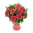 A lush, romantic bouquet of around a dozen deep red roses is displayed in a translucent ruby glass vase against a spotless white studio background, the flowers arranged with the precision and care of an experienced Oxford florist. Each rose is fully open at just the right stage, the velvety petals unfurling in tight, intricate spirals that create a rich, layered texture, like satin folds seen up close. The roses' intense crimson colour dominates the scene, with subtle variations of ruby and wine-red catching the light, evoking warmth, passion, and classic romance. Threaded between the blooms is a generous collar of smooth, dark green foliage, likely ruscus, its glossy leaves arching outward to frame the flowers and give the bouquet a sense of depth and fullness. The foliage's fresh, almost waxy sheen provides a vivid contrast to the softness of the rose petals, echoing the greenery you might see lining the paths in Oxford's University Parks. The red glass vase curves gently from a narrower base to a soft flare at the top, with a faintly ribbed or swirled texture that plays with reflections and shadows, allowing glints of light to pass through and deepen the vase's jewel-toned colour. Through the glass you can just make out the stems, neatly gathered and aligned, giving a grounded, natural feel to this otherwise polished arrangement. The clean white backdrop makes every detail stand out, from the subtle shadows beneath each leaf to the subtle gradations of red and green, turning this bouquet into a striking, emotion-filled centerpiece perfect for conveying heartfelt love on anniversaries, proposals, or Valentine's deliveries throughout central Oxford.