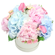 From a skilled florist at Flowers Oxford, this opulent arrangement rests in a pristine white round hatbox, its curves catching the soft morning light that spills across Oxford's skyline. The palette sings in pastel pinks and baby blues, with the star blooms-large pink peonies-opening in lush, velvet petals, while cloud-like mounds of pale blue hydrangeas suspend the arrangement in airy volume. Interlaced among them are delicate spray roses in cream and blush, their buds curling inward as if listening for a whispered compliment, and tightly furled rosebuds that add subtle texture to the dome. Two trumpet-shaped calla lilies in a deeper rose pink rise with quiet drama, one perched near the top-left and the other peeking from the bottom-right, guiding the eye across the sphere. Framing the blossoms, soft green foliage-likely hydrangea leaves and a touch of dusty miller-adds depth and a cool, silvery glow.The bouquet is sculpted into a full, rounded dome, a testament to careful balance and expert placement. Photographed against a pure white background, it reads as a refined gift: elegant enough for a sophisticated birthday or anniversary, yet warm enough to grace a wedding centerpiece in Jericho or the University Parks precinct. Its romance is understated, its craftsmanship evident in every petal and support stem, speaking to the seasonal abundance of Oxford's floral markets. For occasions ranging from baby showers to gender reveals, or simply to say you care, this arrangement delivers quiet luxury and timeless charm, hand-tied with local care by Flowers Oxford and made ready for delivery across the city.