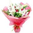 A beautifully composed bouquet of white Oriental lilies and deep red roses is photographed against a pure white background, allowing the colours and forms to stand out with elegant clarity. Dominating the centre and upper part of the design, the lilies appear in varying stages of bloom: some flowers are fully open, with long, slightly recurved petals that create a star-like shape, while a scattering of buds remain closed, their pale green casings tightly wrapped around the petals within. In each open lily, dark, almost chocolate-coloured anthers sit prominently, drawing the eye into the heart of the flower. Between these tall, graceful stems nestle clusters of red roses, their petals thick and velvety, ranging from compact buds to partially opened blooms that show deep, romantic curls at their centres. A generous spread of lush greenery surrounds and supports the flowers, with broad, polished leaves and fine, arching fronds lending depth and texture, much like foliage gathered from the leafy streets of North Oxford or the pathways near Christ Church Meadow. The entire bouquet is wrapped in a voluminous layer of bright pink, glossy cellophane or floral paper that is slightly translucent, forming soft, rippling folds that catch whatever light touches them. At the gathered base of the stems, a narrow lime green ribbon is tied in a neat bow, its fresh, citrus hue providing a lively accent against the pink wrap and deep green leaves. The overall impression is of a joyful, romantic gift-perfect for birthdays, anniversaries, or thoughtful deliveries across Oxford when words alone do not feel enough.