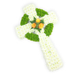 A tender, hand-crafted Celtic cross of fresh flowers occupies the frame, seen from a slight overhead angle against a luminous white background. The main body of the cross is densely packed with small, pure white spray chrysanthemums that read soft and pillowy to the eye, their tiny petals catching the light and suggesting a gentle, linen-like texture. Interwoven into that white field are vivid apple-green button chrysanthemums, placed in neat bands to outline the circular ring where the arms meet and to fill alternating segments of the horizontal arms; their rounded, cushion-like heads give a tactile contrast, almost tangible through sight. Nestled at the very centre where the arms intersect, three fully opened orange roses - warm, golden-amber in tone - create a small, radiant focal point, their velvety petals unfurling with a comforting glow. A few narrow sprigs of deep green foliage, similar to fern fronds, frame the roses and set off the citrus warmth against the cool whites and greens. The overall impression is one of quiet dignity and intentional craft: a sympathy or memorial tribute that also subtly evokes the tricolour of the Irish flag through its white, green and orange hues. Soft studio lighting reveals the cross's three-dimensional form and the delicate shadows between blossoms, while the clean background keeps attention on the arrangement's symbolism. As a florist who works regularly for families in Jericho and Summertown, I picture this piece placed gently at a graveside service or within a chapel, offering a comforting, graceful emblem of remembrance and cultural heritage without overwhelming scent or bravado.