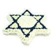 A striking Star of David floral display fills the image, crafted with the kind of precision and reverence that marks a meaningful funeral tribute. The entire six-pointed star is composed of small, tightly packed chrysanthemum blooms, creating a velvety, padded surface that feels both gentle and substantial. A strong outer frame of pure white flowers defines the star's perimeter, while the central hexagon and six inner, inward-facing triangles are also rendered in the same serene white, giving the core of the piece a luminous clarity. Around and between these white areas, the two classic interlocking triangles that make up the Magen David symbol are picked out in deep navy blue blossoms. This darker shade traces clean, decisive lines through the design, echoing the colours of the Israeli flag and speaking clearly of Jewish faith and identity. The interplay of cool white and bold blue is enhanced by soft, neutral lighting, which casts almost no shadows and lets the colours and textures speak for themselves. Every bloom appears freshly opened, aligned with care so that no gaps or stems intrude on the crisp pattern. Created by an experienced Oxford florist familiar with local Jewish traditions, this piece is especially suited to synagogue funerals, memorial services, and graveside tributes across areas like Summertown, Cowley, and central Oxford. It offers a visual prayer of respect and remembrance, a floral star that seems to hold stories, heritage, and love within its carefully woven petals.