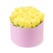 A chic hat box of yellow roses glows against a bright white backdrop, embodying a mix of modern style and classic romance. The design features roughly two dozen fresh yellow roses arranged so closely together that their blooms form a smooth, domed surface, rising slightly above the rim as if ready to spill over with sunshine. Each rose is in perfect form, with dense, velvety petals unfolding from rich, honey-gold centres into softer, lemon-tinted edges, giving the arrangement a sense of depth and gentle movement. You can glimpse just a few slivers of green foliage in between, enough to suggest freshness without distracting from the luminous yellow. The container is a round, pastel pink cylindrical box with a soft, matte texture reminiscent of velvet or suede-its muted blush tone offering a tender contrast to the vibrant roses, much like the balance of old stone and new energy in Oxford's city centre. The minimalist style of the box emphasises the sculptural quality of the flowers, while the clean, white background and even lighting keep the focus entirely on their colour and form. There are no harsh shadows, just a calm, consistent brightness that lets you imagine this arrangement perched on a windowsill in Headington or on a dining table in Summertown. The overall mood is joyful, welcoming, and slightly indulgent-perfect for illustrating a thoughtful flower delivery to mark milestones such as birthdays, new jobs, graduations, or simply to say thinking of you to someone special in Oxford.